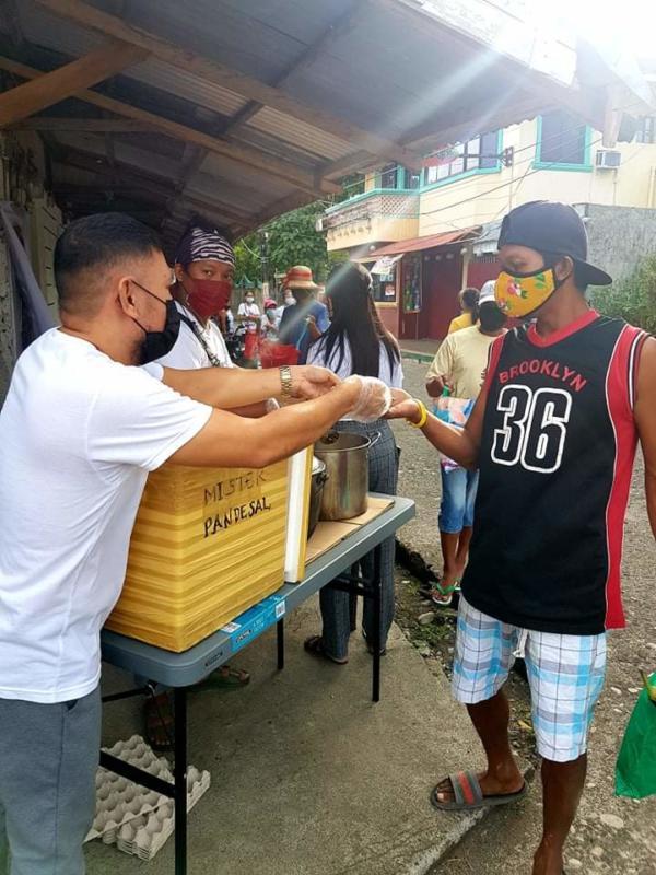 John john distributing Pansit and pandesal (Filipino bread).